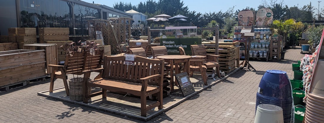 Longacres Bourne Valley wooden outdoor furniture display with wooden benches and companion seating